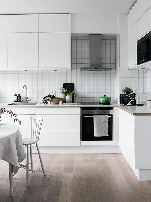 скандинавський дизайн білої кухні з дерев'яною підлогою