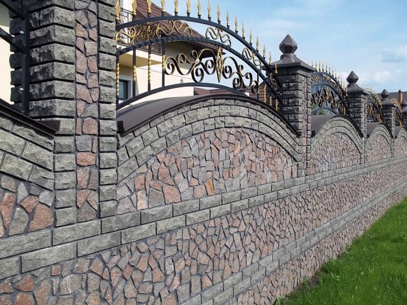 Прикраса паркану з каменю кованими елементами