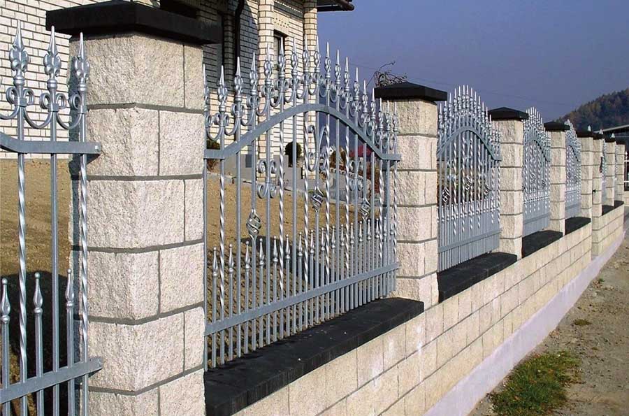 Гарний та високий паркан із металу та каменю