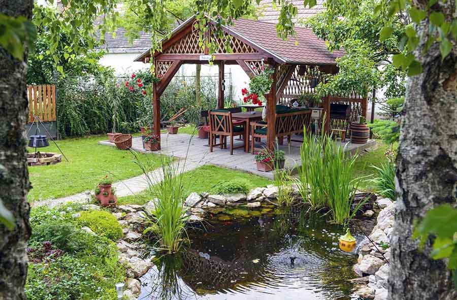 Сучасний садовий ставок з розпилювачем у альтанки