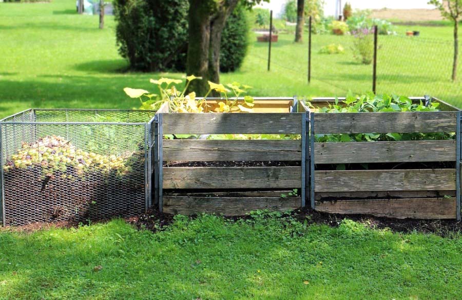 Великі компостні ями з різною огорожею на садовій ділянці