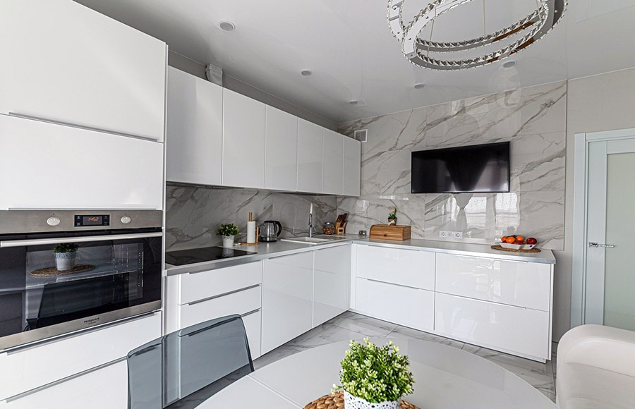Біла хай тек кухня з красивим центральним світильником