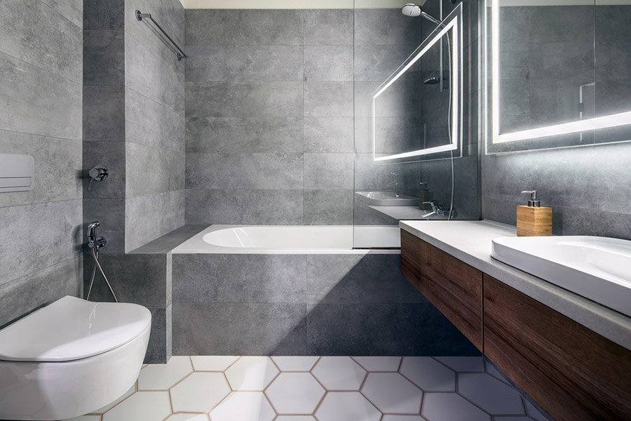 Стильна ванна кімната з великою плиткою у сірих тонах