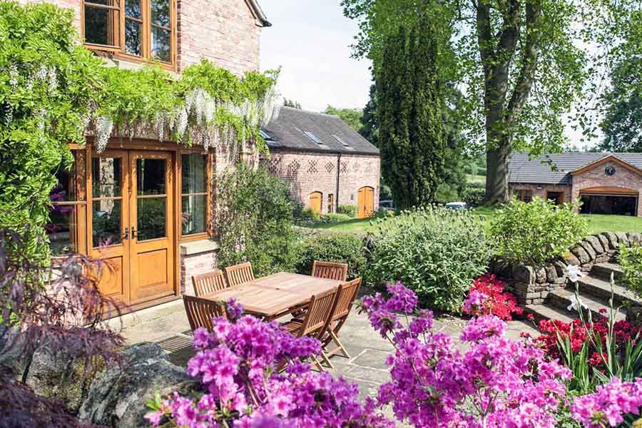 Яскравий задній двір з великою кількістю зелені та квітів