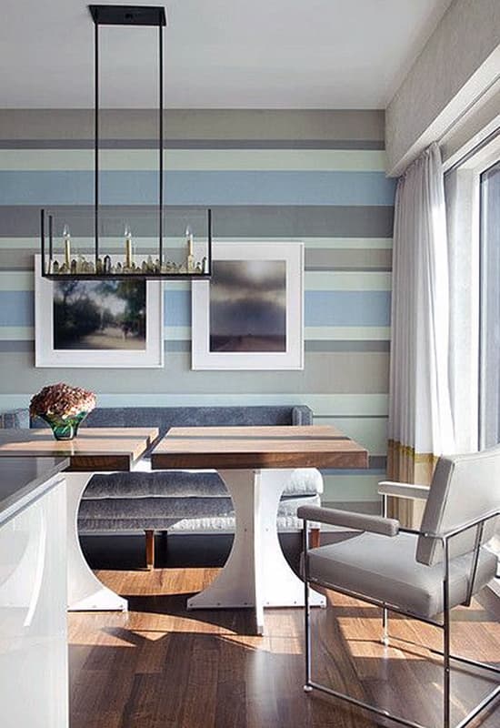 Кухонна стіна зі шпалерами та картинами біля обіднього столу