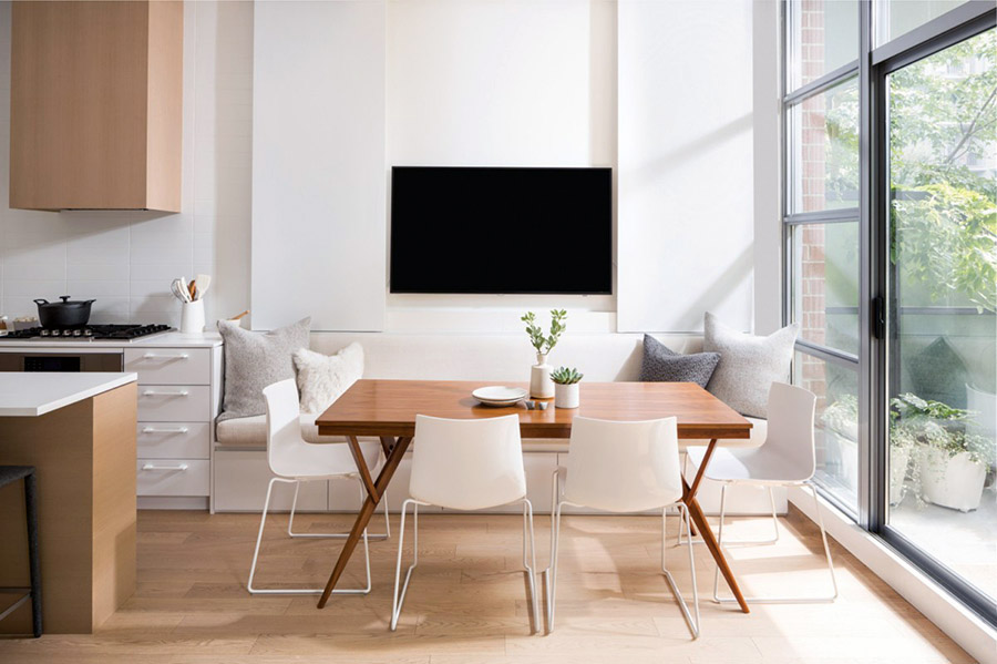 Лаконічний дизайн стіни з телевізором біля обідньої зони на кухні