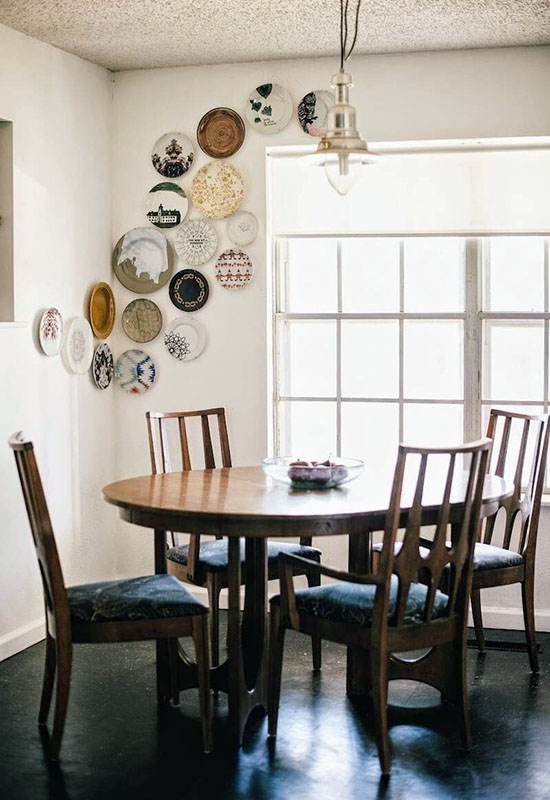 Практичний та стильний декор однотонної стіни біля кухонного столу