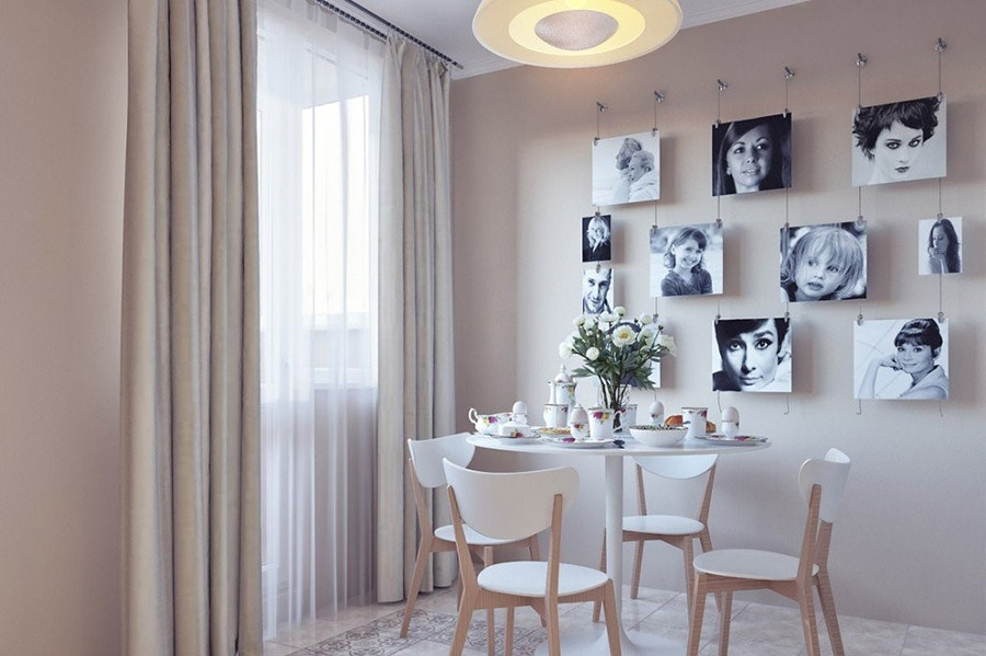 Стіна з декором у вигляді картин на кухні біля столу