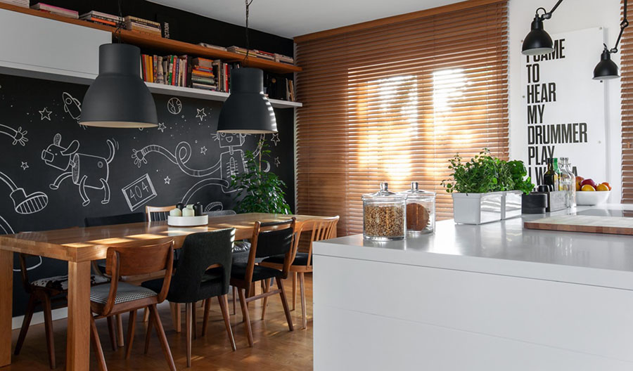 Стильна кухня з грифельним покриттям стіни біля обіднього столу