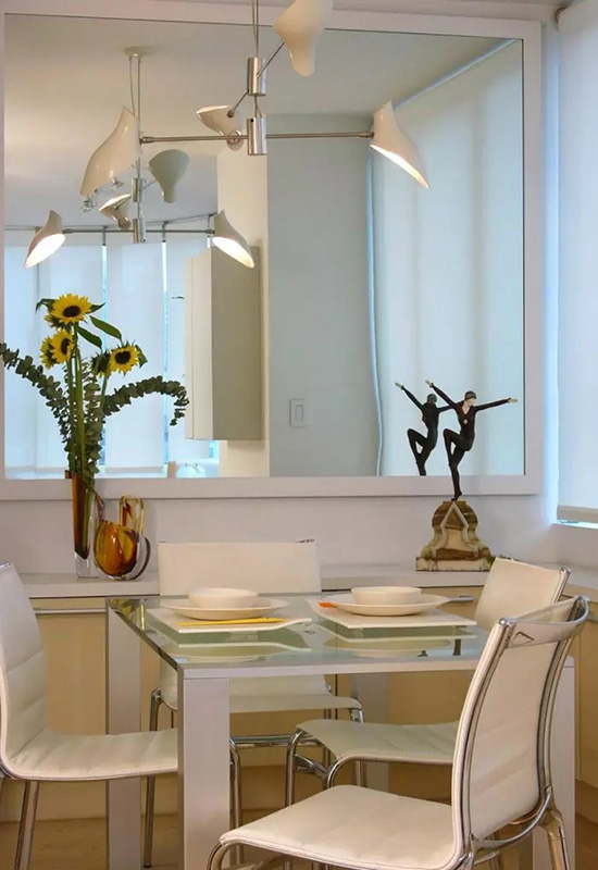 Оздоблення стіни біля кухонного столу великим дзеркалом