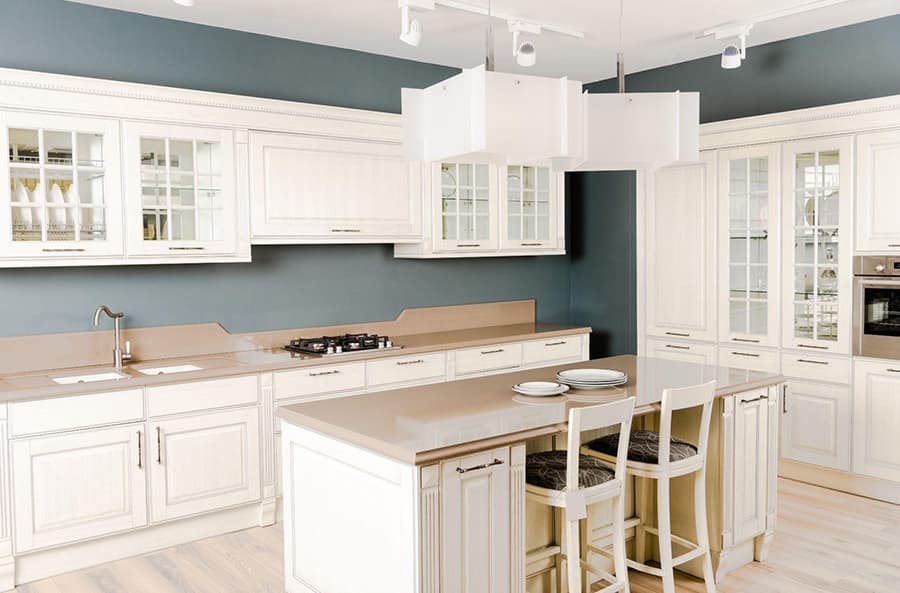 Світло-бежеві меблі в інтер'єрі сірої кухні