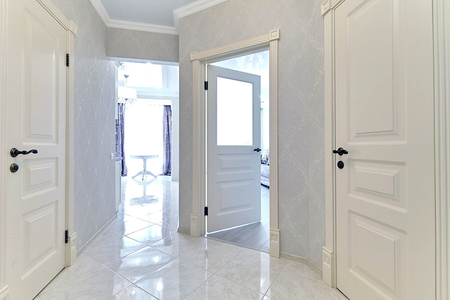 Вузький передпокій зі світлим оздобленням стін