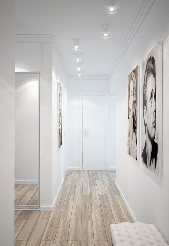 Яскравий вузький передпокій зі світлим дизайном інтер'єру та великими портретами на стінах