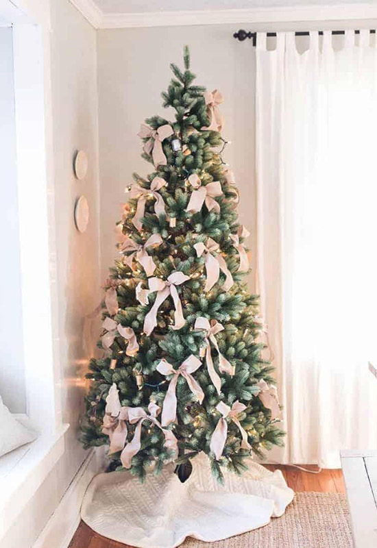 Різдвяна ялинка з великими світлими бантами