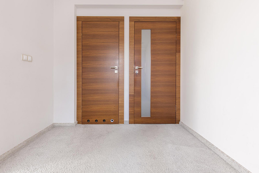 Міжкімнатні двері з коричневими відтінками в інтер'єрі білої кімнати