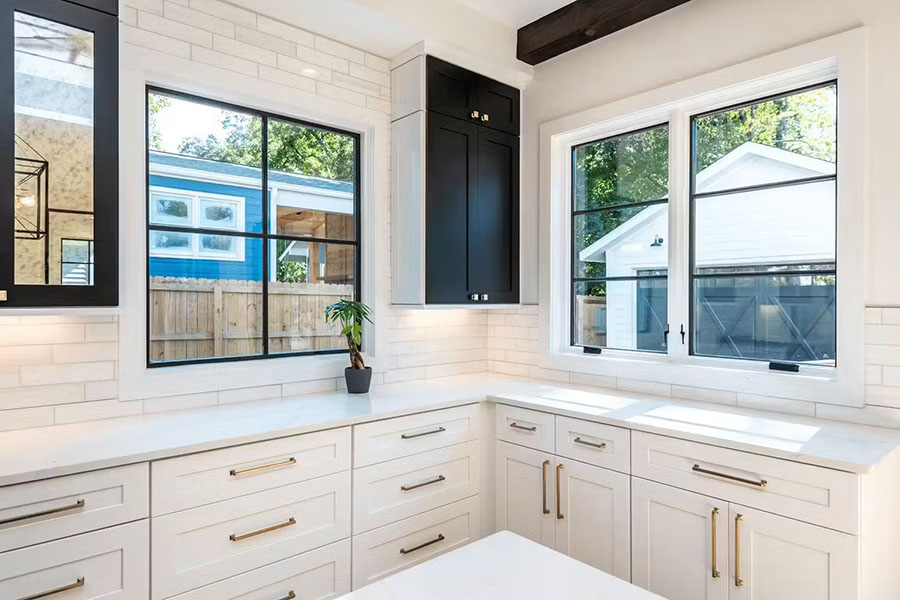 Світла кутова кухня з великими вікнами та сучасним інтер'єром