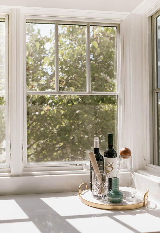 Інтер'єр кухні в білих відтінках із великим вікном