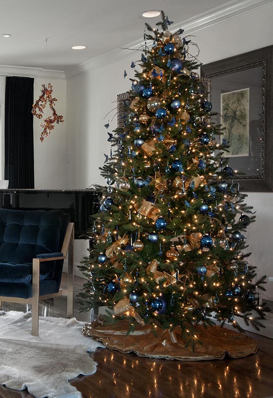 Поєднання синіх іграшок і золотистих гірлянд на новорічній ялинці